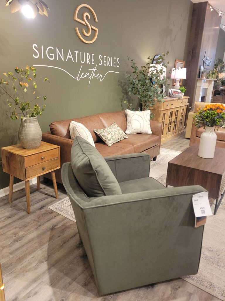 Leather sofa with earthy green chair and accent tables in a showroom