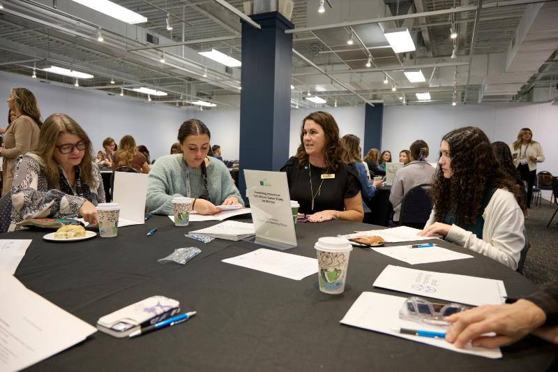 Women gathered at tables at a conference