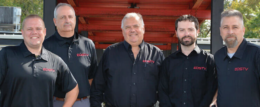 Five men in black shirts with the logo EDS TV